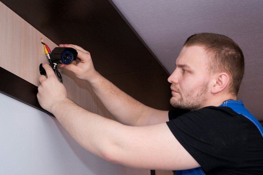 A handyman fitting trim on a wall