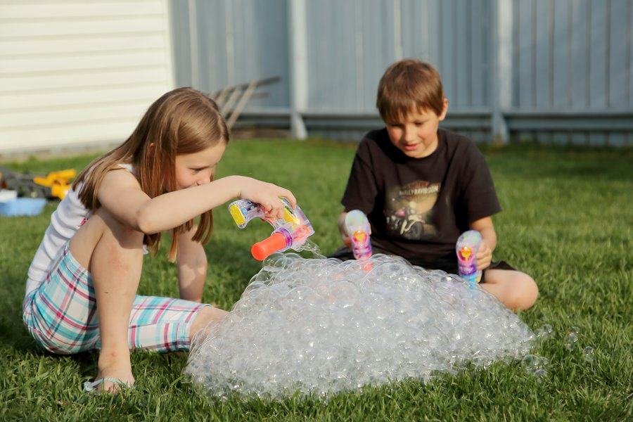 Two kids playing on a green, freshly mowed lawn